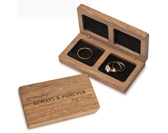 May include: A wooden ring box with two compartments, one for each ring. The box is engraved with the words "Always & Forever".