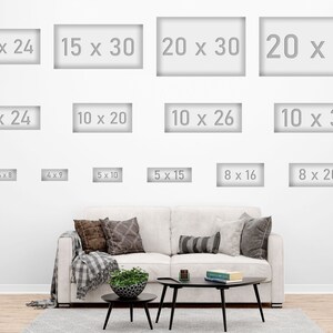 May include: A white wall displays various rectangular art print sizes, including 12x24 inches, 15x30 inches, and 20x40 inches. A sofa with pillows and a coffee table are in the foreground.