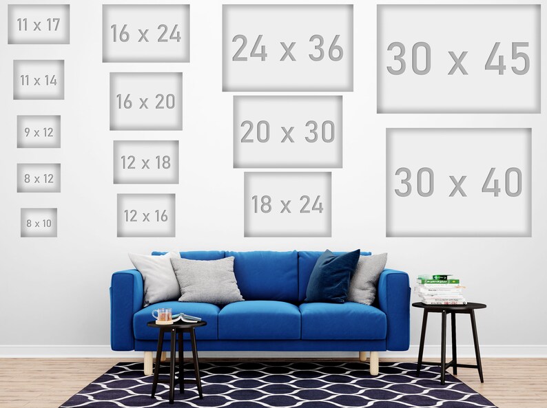 May include: A white wall displays various framed art sizes, including 11 x 17 inches, 16 x 24 inches, and 30 x 45 inches. A blue sofa with pillows and a black side table with decor are in front of a patterned rug.