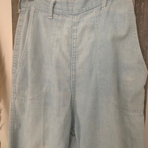 May include: Light blue high-waisted denim pants with a straight leg and multiple pockets.