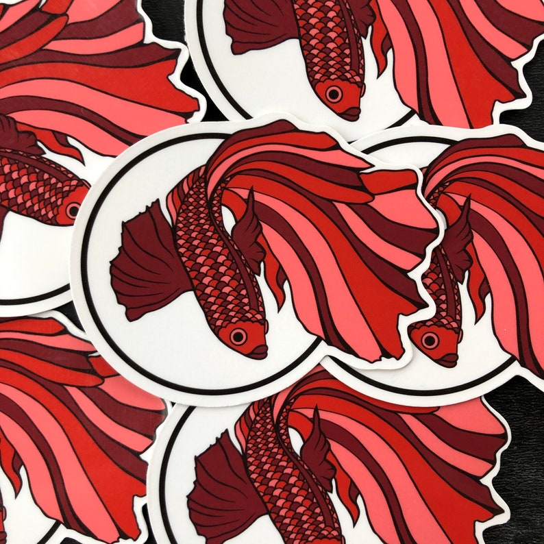 May include: A set of five stickers featuring red and pink betta fish with flowing fins. The fish are illustrated in a stylized, graphic style.