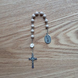 Baseball-Rosenkranz ist im Taschenformat / einzelnes Jahrzehnt mit beigefarbener Rund- / Baseballperle, detailliertem Kruzifix und Saint Sabastian-Medaille.