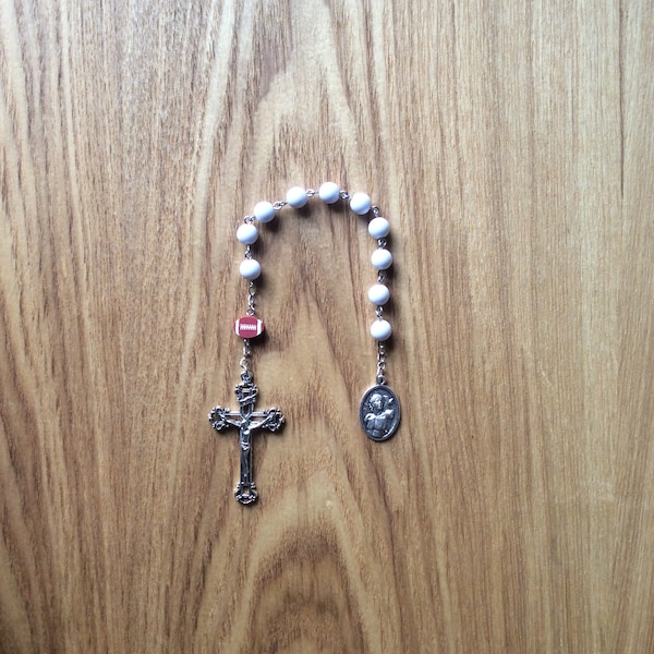 Football Rosary is pocket size with white round/football bead, detailed Crucifix and Saint Sabastian (patron Saint of athletes) medal.