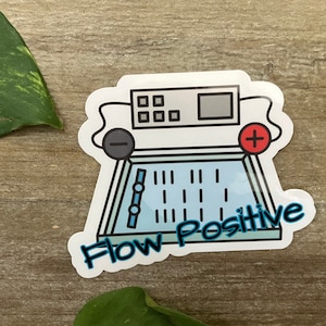 May include: A white sticker with a blue and white illustration of a medical device with the text "Flow Positive" in blue.