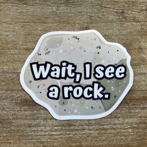 May include: A white sticker with a cartoon rock and the text "Wait, I see a rock."