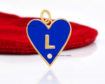 May include: A gold heart-shaped pendant with a blue enamel finish and a single diamond. The pendant features the letter "L" in gold.