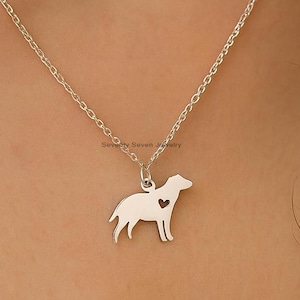 May include: A silver dog pendant necklace. The pendant is a silhouette of a dog with a heart-shaped cutout. The necklace has a fine chain. The dog shape is smooth and polished, with a heart detail.