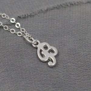 May include: A silver chain necklace with a delicate pendant shaped like the infinity symbol.