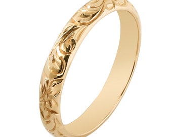 May include: A simple gold band ring with a floral design engraved around the entire band.