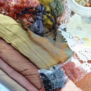 Peut inclure: Un assortiment de fournitures de bricolage comprenant des chutes de tissu dans les tons marron, rose et jaune, ainsi que divers fils, perles et dentelles. L'image présente une variété de textures et de couleurs, parfaites pour les projets créatifs.