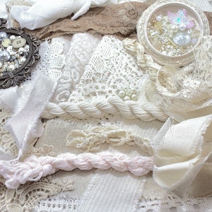 Peut inclure: Un assortiment de dentelles, rubans et chutes de tissu ivoire et crème. L'image comprend un cadre ovale décoratif rempli de perles et de boutons, et un petit récipient rond avec des embellissements irisés. Les textures varient de lisses à rugueuses.