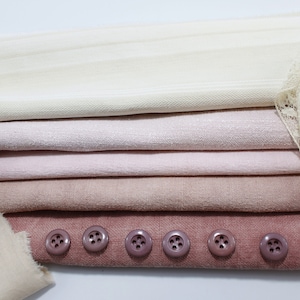 Peut inclure: Un assortiment d'échantillons de tissus dans différentes nuances de rose et de beige, avec une dentelle et une rangée de six boutons marrons.