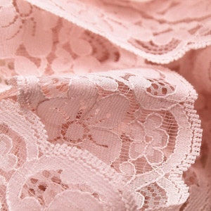 Peut inclure: Gros plan sur une dentelle rose délicate avec un motif floral. La dentelle a un aspect doux et romantique et est parfaite pour ajouter une touche d'élégance à tout projet.
