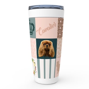 Pode incluir: Um copo de aço inoxidável branco com um design de patchwork que apresenta um Cavalier King Charles Spaniel, uma coroa e padrões florais. O texto "Cavalier" está impresso no copo.