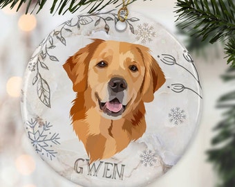 May include: A white ceramic Christmas ornament with a golden retriever dog illustration and the name "GWEN" printed on the bottom. The ornament has a white marble background with a gray floral design and snowflakes.