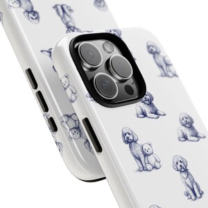 May include: White phone case featuring a repeating pattern of blue poodle and teddy bear illustrations. The case has a black camera lens border and side buttons. The design is a playful and whimsical style.