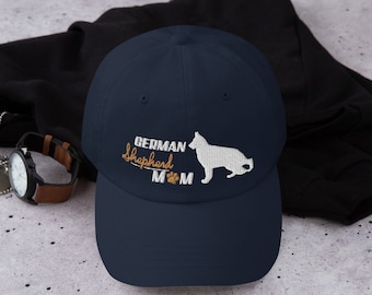 May include: A navy blue baseball cap with the embroidered text "German Shepherd Mom" and a paw print. The cap features a white silhouette of a German Shepherd dog.