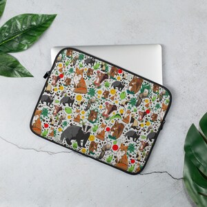 May include: A white laptop sleeve with a colorful pattern of foxes, badgers, squirrels, and other woodland creatures. The sleeve has a black zipper and a black border.