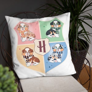 May include: White pillow with a colorful design featuring four cartoon dogs wearing scarves. Each dog is in a different colored square with a letter "H" in the center.