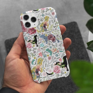 May include: White iPhone case with a floral pattern featuring pink, purple, and blue flowers and green leaves. Silhouettes of dogs are scattered throughout the design.
