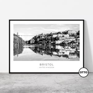 Peut inclure: Impression encadrée en noir et blanc de Bristol, Royaume-Uni. L'image représente un pont sur une rivière avec des bâtiments sur une colline. Le mot "BRISTOL" et "UNITED KINGDOM" sont imprimés en blanc au bas de l'impression.