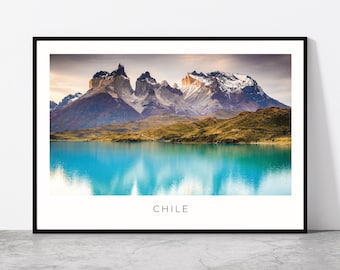 May include: A framed print featuring a scenic landscape of the Chilean Andes mountains. The image showcases a turquoise lake reflecting the peaks, with the word "CHILE" at the bottom. The mountains have snow-capped peaks.