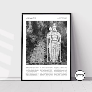 May include: A black and white photograph of a large statue of a Hindu deity in front of a cave entrance. The statue is standing on a set of stairs leading up to the cave. The image is captioned "MALAYSIA" and "SOUTHEAST ASIA 4.2105°N, 101.6879°E".