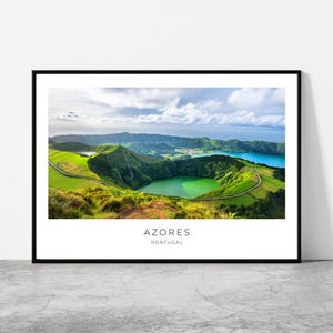 May include: A framed print featuring a scenic landscape of the Azores, Portugal. The image showcases a vibrant green lake surrounded by lush, rolling hills and a blue lake in the background under a cloudy sky. Text at the bottom reads "AZORES PORTUGAL."