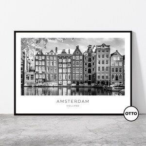 May include: Black and white framed print depicting a canal scene in Amsterdam, Holland, with a row of buildings. The print includes the city and country name. The image is in monochrome.