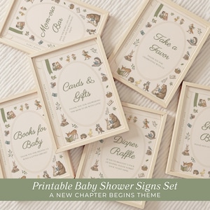 May include: A set of five framed signs with light wood frames, featuring cream-colored backgrounds and illustrations of woodland animals reading books. The signs include text for a Mom-osa Bar, Cards & Gifts, Books for Baby, Diaper Raffle, and a Guest Book.