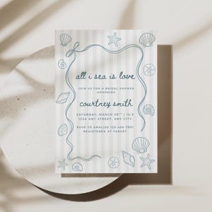 May include: A rectangular bridal shower invitation card with a light blue and white vertical striped background. The card features a blue line-art border with seashells and starfish, and the text: all i sea is love, JOIN US FOR A BRIDAL SHOWER HONORING, courtney smith, SATURDAY, MARCH 30TH | 12-3, 1234 ANY STREET, ANY CITY, RSVP TO ANALISE 123-456-7891, REGISTERED AT TARGET.