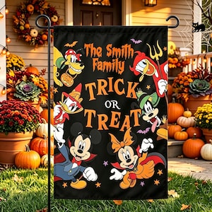 May include: A black rectangular garden flag featuring the text The Smith Family TRICK OR TREAT in orange. The design includes cartoon characters dressed in Halloween costumes, including a vampire, a witch, and a devil, surrounded by bats.
