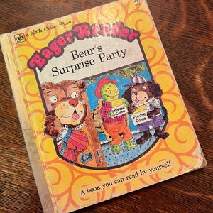 May include: A yellow and orange book cover with the title "Eager Reader" and the words "Bear's Surprise Party". The cover features illustrations of a bear, a turtle, and a dog holding signs that say "Please Come".