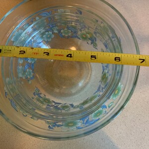 May include: Set of four glass mixing bowls with a floral design in shades of blue and green. The bowls are nested inside each other and measure 8 inches in diameter.