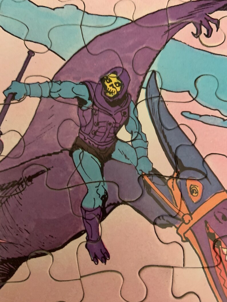 May include: A purple and blue cartoon character riding a purple and blue flying creature. The character is wearing a purple hooded cloak and has a skull face. The creature has a long beak and a yellow eye.