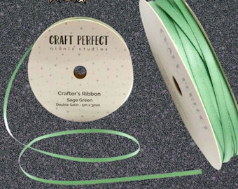 May include: Sage green double satin crafter's ribbon from Tonic Studios. The spool of ribbon is 5m long and 3mm wide. The text "Craft Perfect" and "Crafter's Ribbon" are printed on the spool. The ribbon is unspooled in a loop.