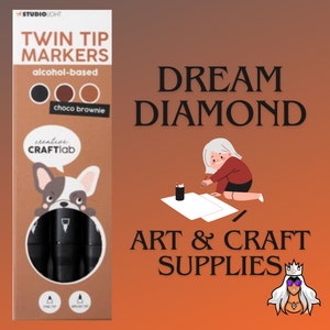 May include: A package of twin tip markers with a black and white illustration of a French bulldog. The markers are alcohol-based and come in three colors: black, brown, and light brown. The package says "choco brownie" and "creative CRAFTlab".