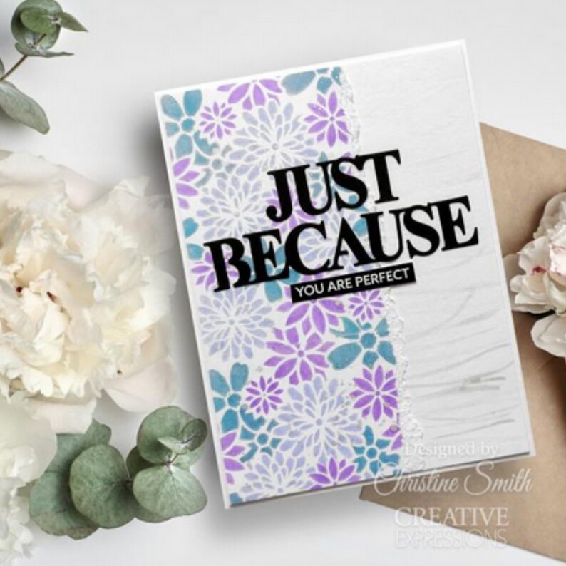May include: A white card with a purple and blue floral pattern. The text "JUST BECAUSE YOU ARE PERFECT" is printed in black on the card.