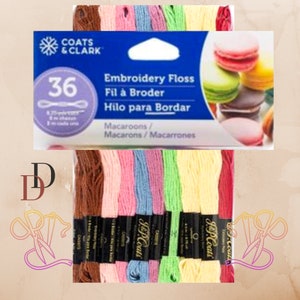 Könnte beinhalten: Eine Packung mit 36 Spulen Coats & Clark Stickgarn in verschiedenen Pastellfarben. Die Verpackung zeigt ein Design mit Macarons und den Text "Embroidery Floss, Fil à Broder, Hilo para Bordar, Macaroons/Macarons/Macarrones".