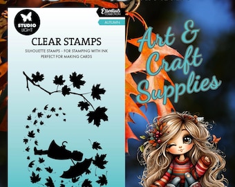 May include: Clear stamps for card making featuring a silhouette of a person with an umbrella and falling leaves. The stamps are from the Studio Light Essentials Collection, Autumn. The image also includes the text "Dream Diamond" and "Art & Craft Supplies".