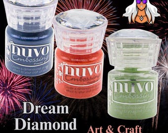 May include: Three Nuvo embossing powder jars in blue, red, and green, each with a clear, faceted lid. The jars are labeled with the brand name and product details. The image includes the text "Dream Diamond Art & Craft Supplies."