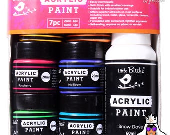Puede incluir: Un juego de pintura acrílica Little Birdie con siete piezas. El juego incluye seis botes de pintura de 20 ml en frambuesa, iris bloom, lime punch y sea wave, más una botella de 60 ml de snow dove. El embalaje presenta el texto "ACRYLIC PAINT".