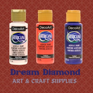 May include: Three bottles of DecoArt Americana acrylic paint in Baby Blush, Teaberry, and Twilight colors. Each bottle is 2 fl. oz. and has a gold cap. The image also displays the text "Dream Diamond ART & CRAFT SUPPLIES."