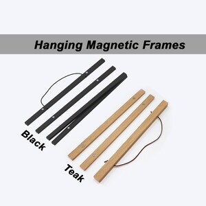 Op de afbeelding: Twee sets hangende magnetische frames, een zwart en een van teakhout. Elke set bevat drie frames met een touwtje om op te hangen.