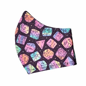 May include: A black face mask with a repeating pattern of colorful dice with white numbers on a black background. The dice are in shades of pink, blue, green, and yellow.