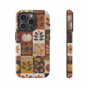 Op de afbeelding: Een telefoonhoesje met een patchwork-ontwerp met pompoenen, bloemen en bladeren in herfstkleuren. De hoes heeft een zwarte rand en een zijaanzicht dat de voortzetting van het patroon laat zien. Het ontwerp is een mix van oranje, geel en bruin.