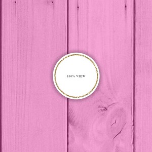 May include: A white circle with a gold glitter border on a pink wood background. The circle contains the text "100% VIEW".