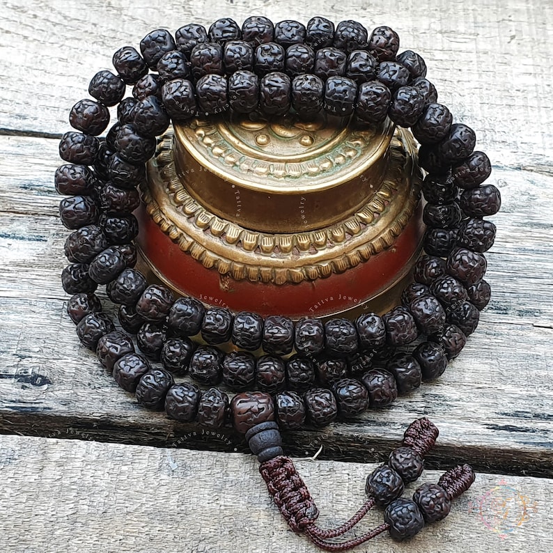 108 Natural Aged Dark Black Rudraksha Seed Mala from Nepal, handcrafted for meditation, prayer, and spiritual practices. This sacred Rudraksha Japa Mala is tumbled for comfort, naturally stained, and oiled for a rich aged appearance. Ideal for mantra chanting, mindfulness, and Buddhist or Hindu rituals. Bead size: 9.5-10.5mm, Mala length: 31-33 inches. A powerful meditation tool promoting inner peace, protection, and spiritual growth. Authentic, high-quality Nepalese Rudraksha mala.