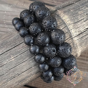 Op de afbeelding: Een armband bestaande uit meerdere strengen ronde, poreuze zwarte lavastenen kralen. De kralen hebben een natuurlijke, ruwe textuur en zijn geregen in een dichte, meerlaagse opstelling. De tekst Tattva Jewelry is zichtbaar op de afbeelding.