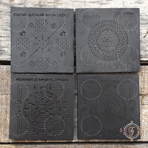 May include: Four black square tiles with intricate designs and text in a foreign language. The tiles are arranged in a 2x2 grid. The top left tile features a square with numbers and symbols. The top right tile features a circle with a triangle inside. The bottom left tile features a circle with a complex design inside. The bottom right tile features a triangle inside a circle.